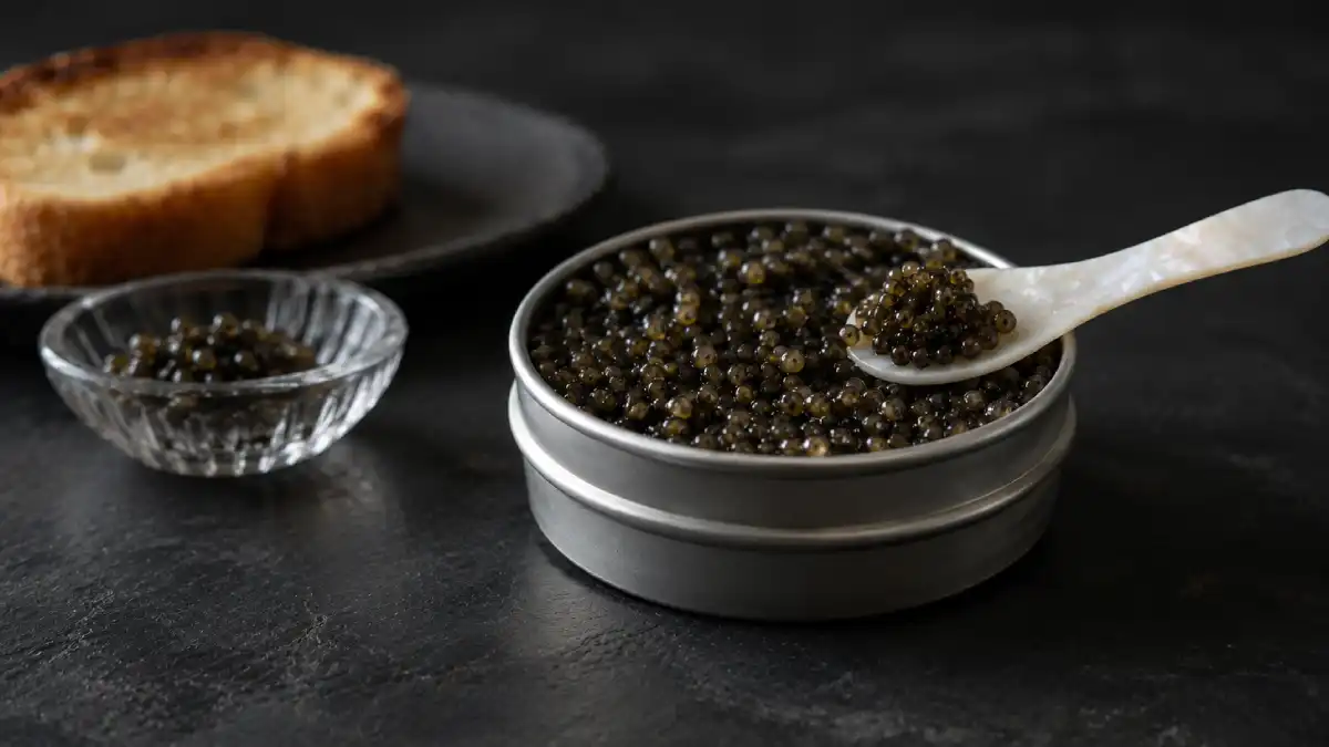 Open 30 g tin of Ossetra caviar with a mother-of-pearl spoon and toasted brioche